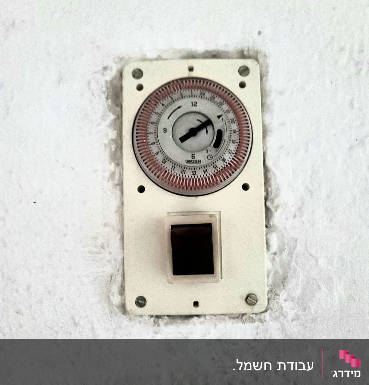 שעון טיימר חשמלי מותקן על קיר לבן